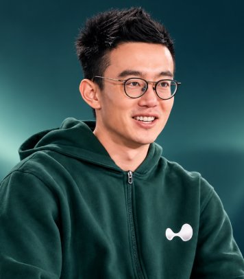 Portrait of Hyperliquid founder Jeff Yan wearing glasses and a green hooded sweatshirt.