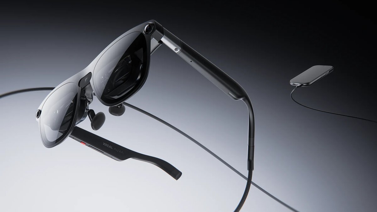 Xreal Aura wired smart glasses shown connected by a cable to their companion computing puck.