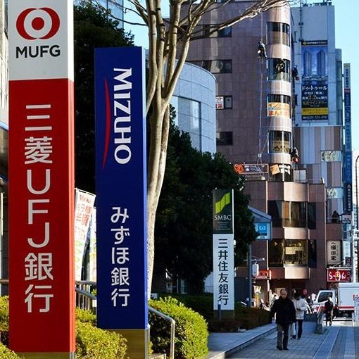 Street view showing branch signs for Japan's three megabanks: MUFG, Mizuho Bank, and SMBC.