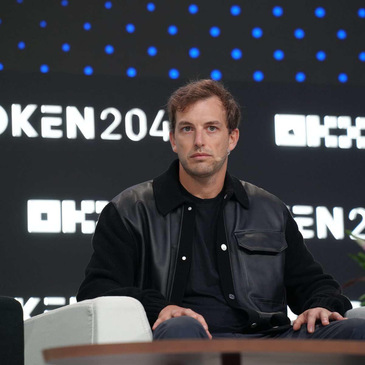 Zak Folkman seated on stage during a panel at Token2049.