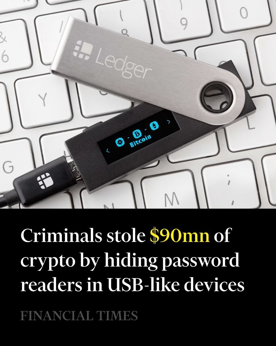 A Ledger hardware wallet connected by a USB cable rests on a computer keyboard.