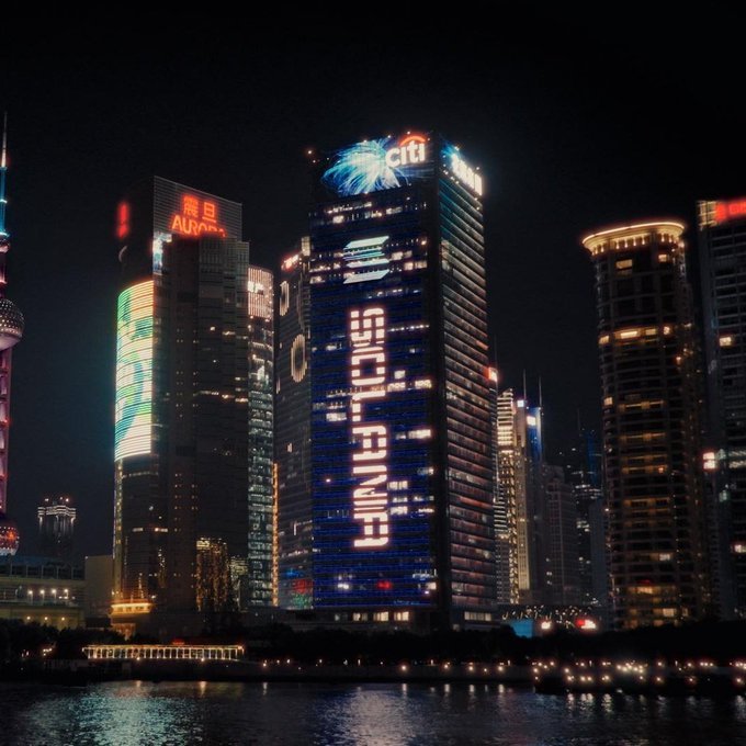 A night view of Shanghai skyscrapers with one building displaying the illuminated Solana logo and text across its facade.