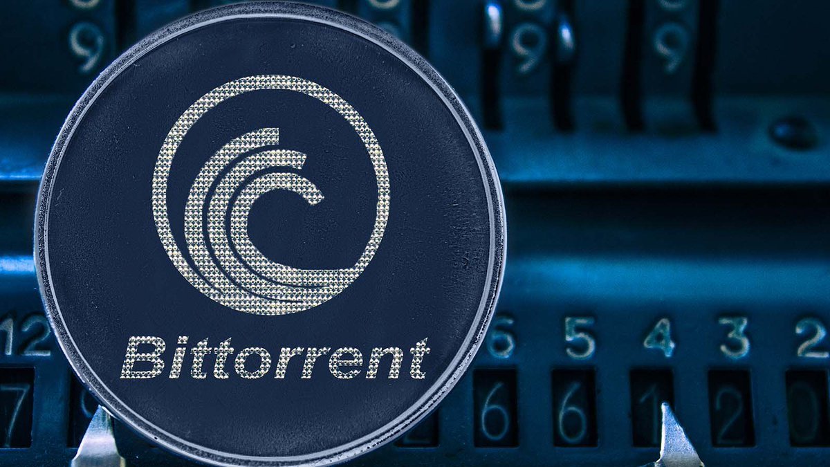 A round token featuring the BitTorrent name and logo resting on an antique mechanical counter.