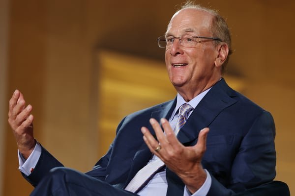 BlackRock CEO Larry Fink speaking while gesturing with his hands during a panel discussion.