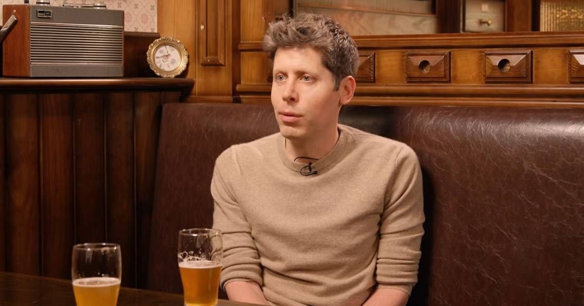 OpenAI CEO Sam Altman seated in a booth with drinks on the table during an interview.