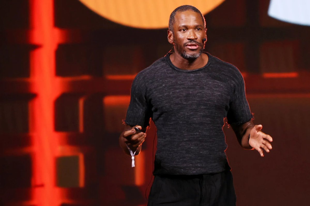 Arthur Hayes gesturing with his hands while speaking on a conference stage.