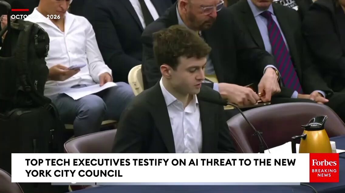 Jacob Coxon testifying at a microphone before the New York City Council during a hearing on artificial intelligence safety risks.