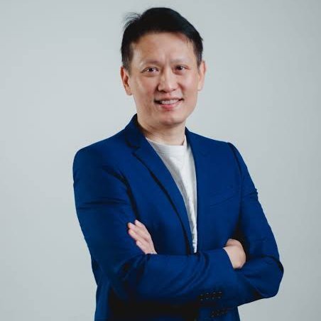 Portrait of Binance Co-CEO Richard Teng in a blue suit jacket.