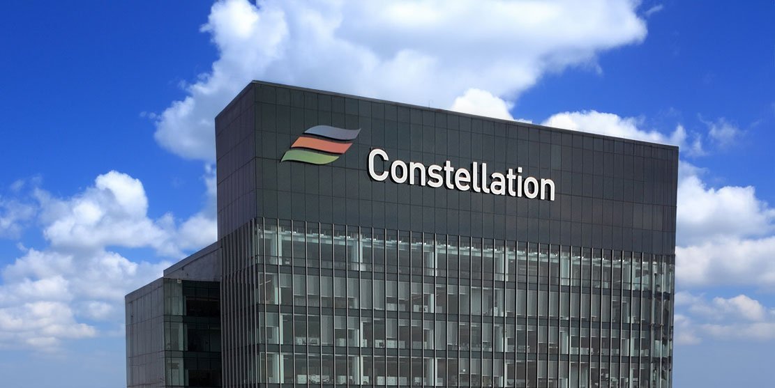 Exterior view of the Constellation Energy corporate building with company logo against a blue sky.