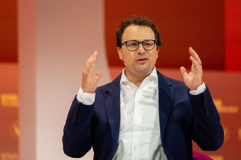 Anthropic CEO Dario Amodei speaking on stage with his hands raised