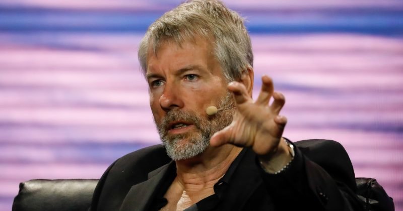 Michael Saylor speaking with a microphone headset and gesturing during an event.