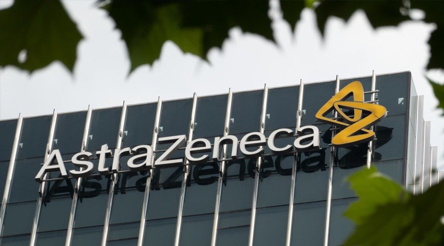 AstraZeneca logo on an exterior office building wall behind green leaves.