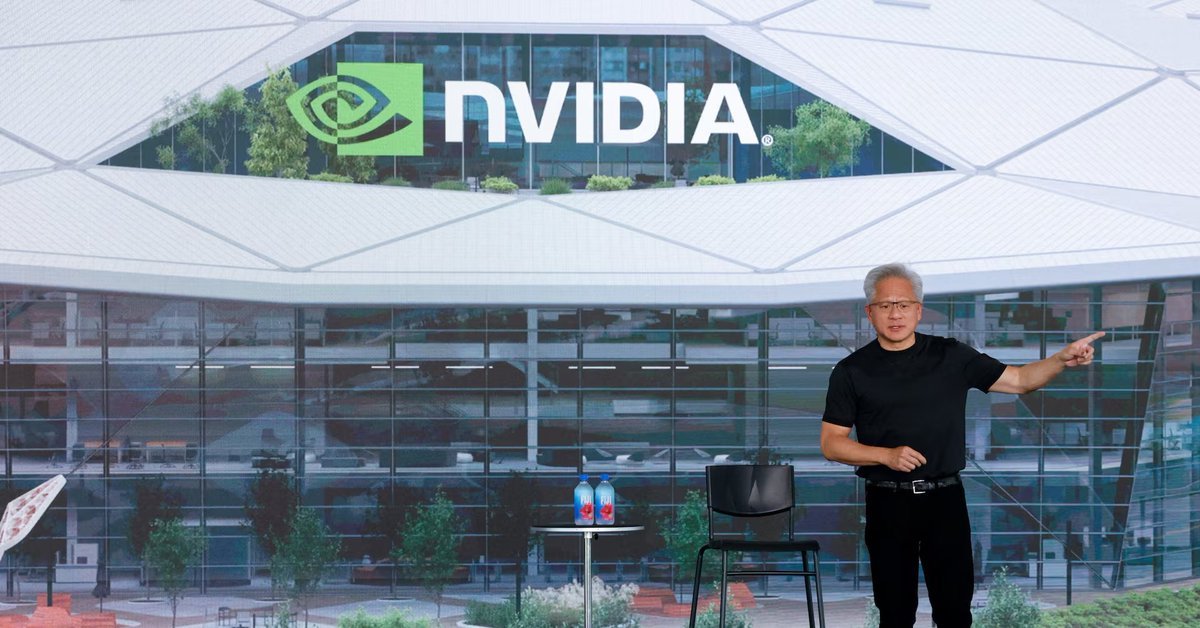 Nvidia CEO Jensen Huang gestures on stage in front of a backdrop showing an architectural rendering with the Nvidia logo.