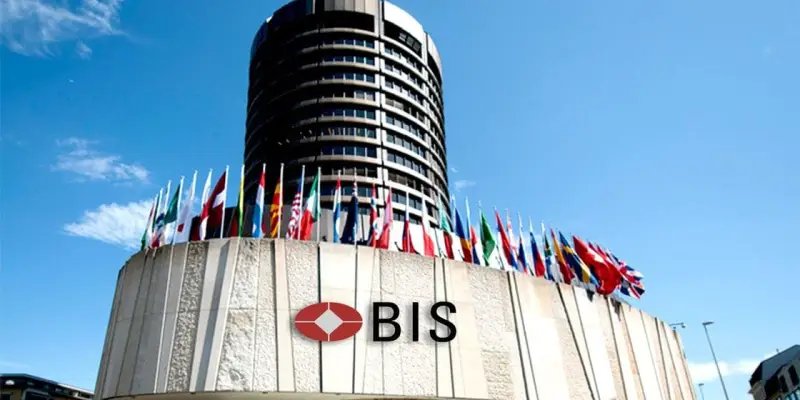 Exterior view of the Bank for International Settlements (BIS) headquarters building in Basel, Switzerland, adorned with international flags.