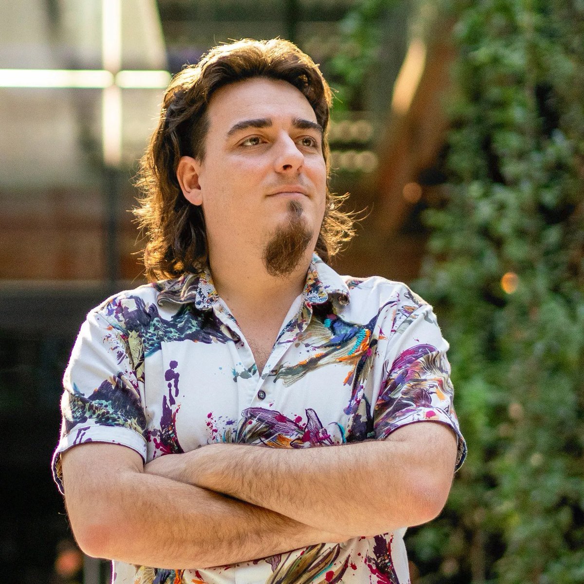 Portrait of Palmer Luckey, founder of Anduril Industries, outdoors with arms crossed.