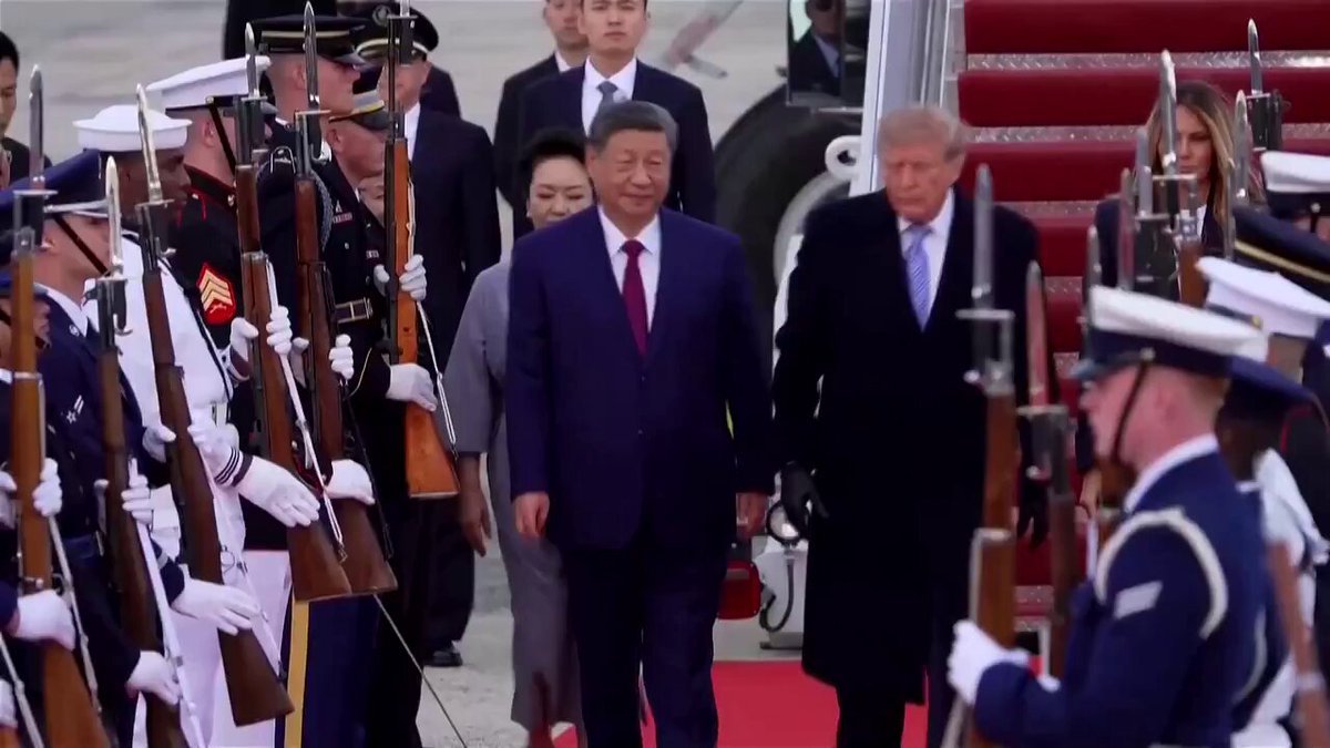 President Donald Trump and Chinese President Xi Jinping walk along a red carpet flanked by a military honor guard upon Xi's arrival.