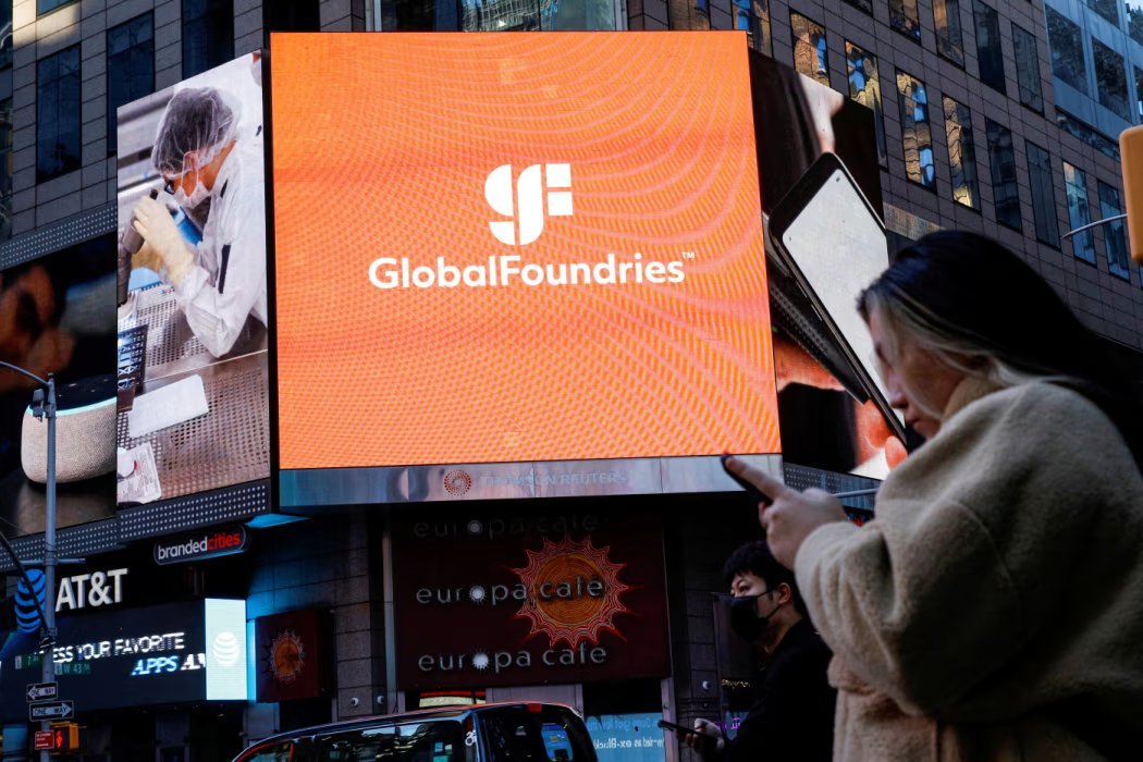 A large outdoor digital screen displays the GlobalFoundries logo and branding above a city street.