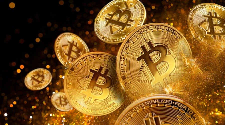 Physical Bitcoin tokens shining amidst golden glitter and bokeh against a dark background.