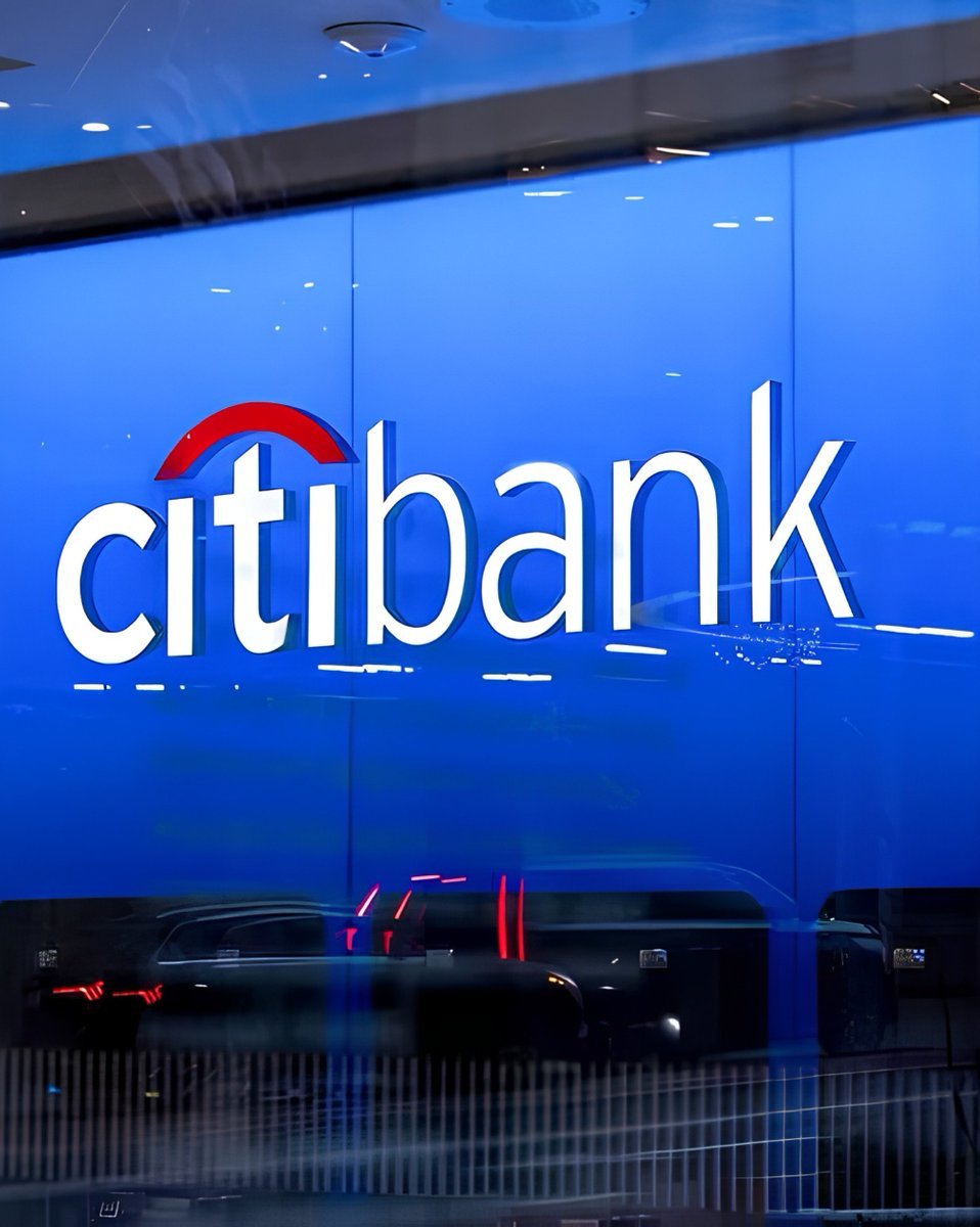 An illuminated Citibank logo and sign mounted on a glass facade.