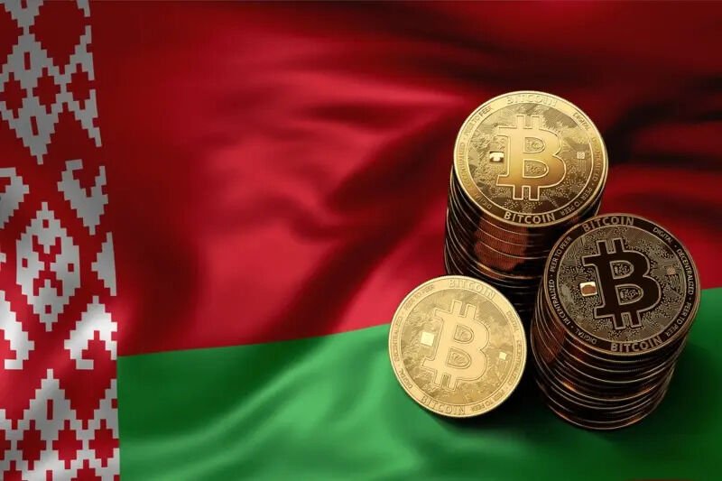 Physical Bitcoin coins stacked on the national flag of Belarus.