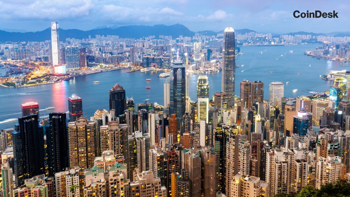 Aerial view of the Hong Kong skyline and Victoria Harbour at dusk.