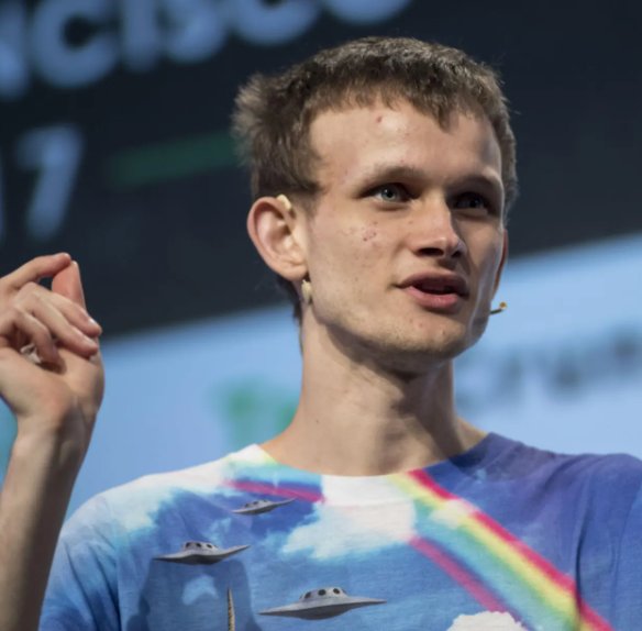 Ethereum co-founder Vitalik Buterin speaking at an event in a colorful t-shirt.