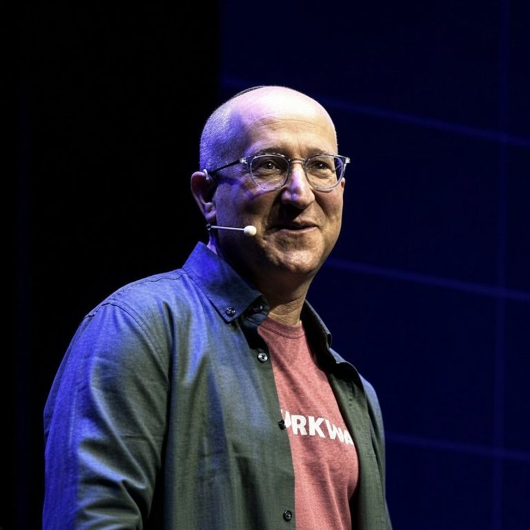 StarkWare CEO and co-founder Eli Ben-Sasson smiling on stage with a headset microphone.