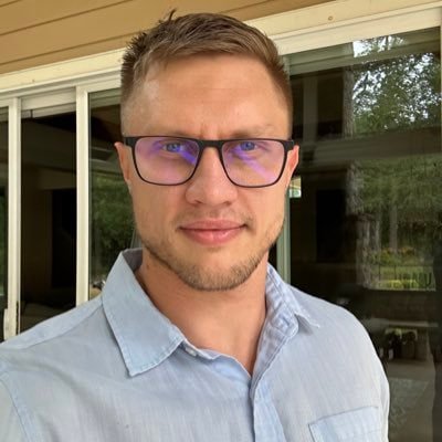 Portrait of Tornado Cash co-founder Roman Storm wearing glasses and a light blue collared shirt.