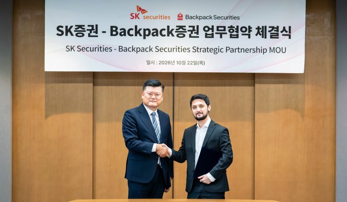 Two representatives shake hands at an MOU signing ceremony beneath a banner reading SK Securities - Backpack Securities Strategic Partnership MOU.