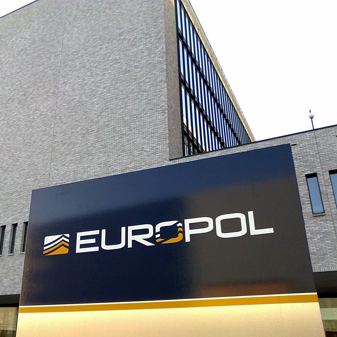 Europol headquarters building exterior with the Europol logo displayed on a large sign in front.