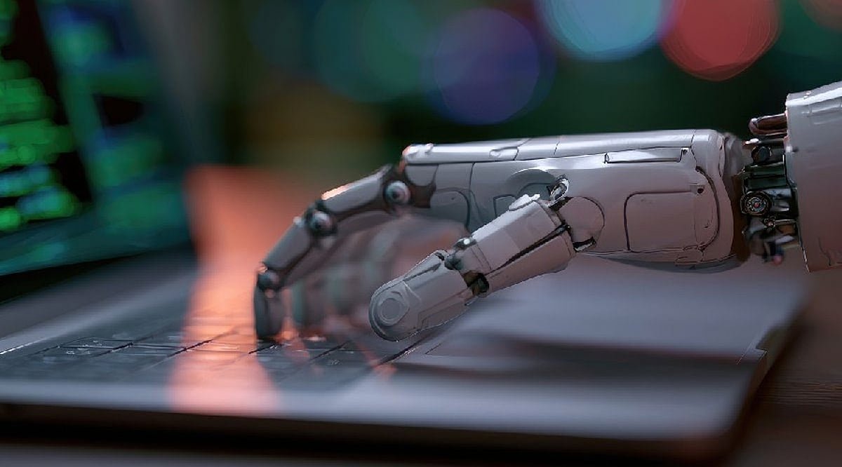 An illustrative image of a robotic mechanical hand typing on a laptop keyboard.